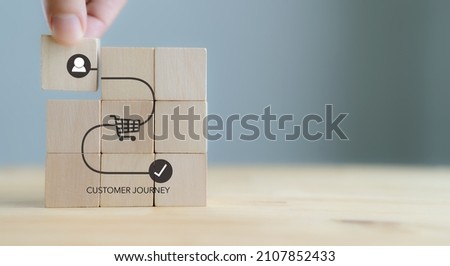 Customer journey concept on wooden cubes on grey background. Business and social media marketing,  content marketing, purchase, storytelling, seo, awareness, advertise, online marketing and promotion.