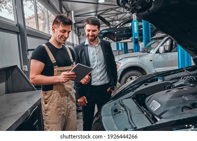 Customer listening to his mechanic at the repair garage. Selective focus. - Powered by Shutterstock