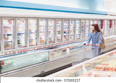 Customer looking for a product in the frozen aisle of a supermarket