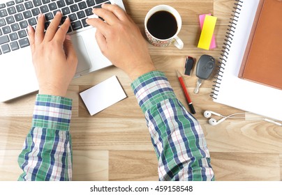 Customer Looking For Some Online Services With Blank Business Card While Working His Office. The Wooden Table Contains Laptop, Black Tea, Car Key, Pen Drive, Office Articles And Business Card.