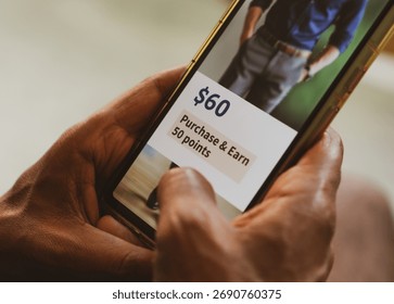 Customer loyalty program concept in e-commerce. Man holding phone displaying earning points after purchasing online.