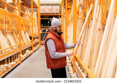 A Customer In A Lumber Store Chooses Bars And Boards For A Frame House