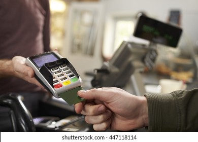 Customer Makes Credit Card Payment Over Counter At A Cafe