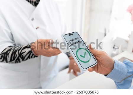Customer making a contactless payment using their smartphone in a beauty salon, showing successful transaction