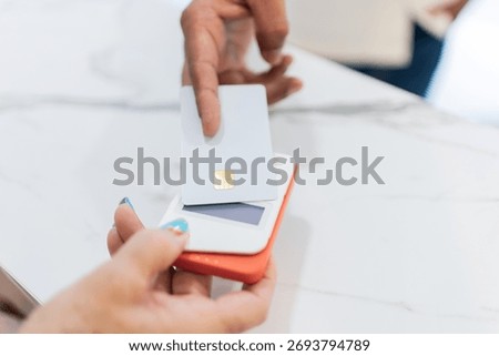 Customer making contactless payment using credit card at point of sale terminal