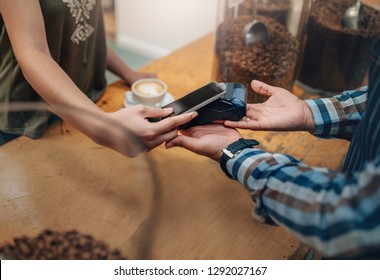 Customer making wireless or contactless payment using credit card using NFC technology. focus on hands