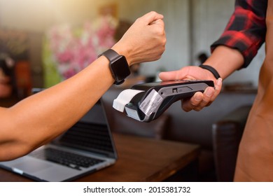 Customer making wireless or contactless payment using smartwatch. Store worker accepting payment over nfc technology.shallow depth of field - Powered by Shutterstock