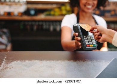 Customer Making Wireless Or Contactless Payment Using Credit Card. Smiling Cashier Accepting Payment Over Nfc Technology.