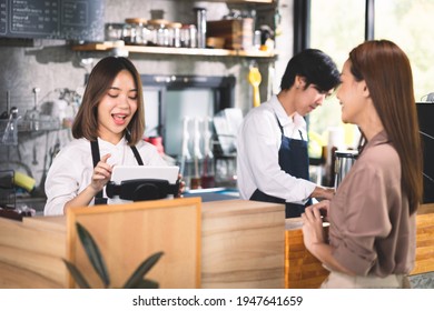 A Customer Orders A Hot Latte To The Barista. Asian Staff Coffee Shop Cafe Making Hot Coffee And Serve To Customer. Small Business Sme Concept.