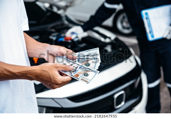 Customer pay with\
money for repair to the mechanic at garage workshop, Spending and\
car financial concept.