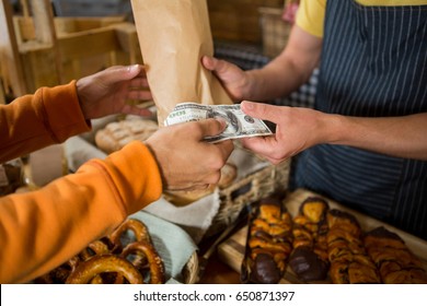 Customer Paying Bill By Cash At Bread Counter In Bakery Shop