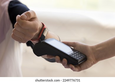 Customer paying bill for service, purchase, order in cafe, applying smartwatch to payment terminal for contactless electronic transaction, using online mobile bank service for smart gadget - Powered by Shutterstock