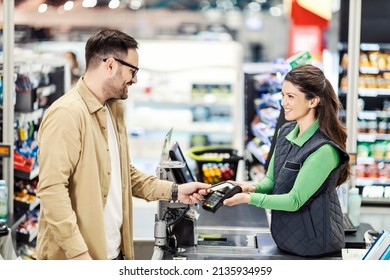 A customer paying with credit card at checkout in hypermarket. - Shutterstock ID 2135934959