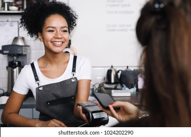 Customer Paying With Her Mobile Phone At A Small Cafe