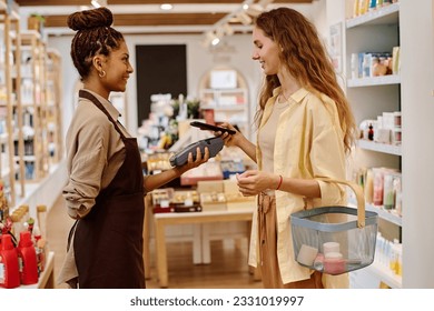 Customer paying for purchase with smartphone - Shutterstock ID 2331019997