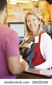 Customer Paying For Shopping At Supermarket Checkout