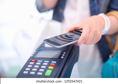 Customer is paying with smartphone in shop using NFC technology. NFC technology. Customer is paying
