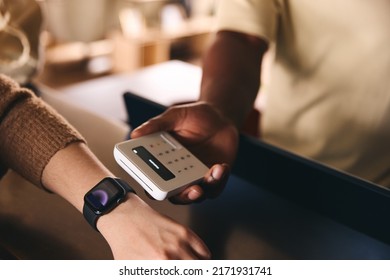 Customer Paying Using Smart Watch Mobile Payment NFC Contactless Technology In Retail Store - Powered by Shutterstock