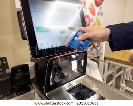 Customer pays his purchase at the supermarket,self checkout systems in  retail stores,Barcode scanner,Self checkout machine