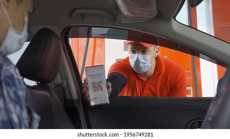 A customer, people, paying gas bill by scanning QR code, online payment, wearing a face mask at gasoline petrol station, an online payment option refuel oil. Business service. Coronavirus pandemic.