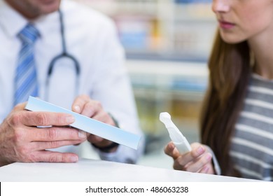 Customer and pharmacist reading pregnancy test in pharmacy - Powered by Shutterstock