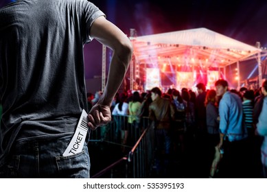 Customer presenting tickets or admission passes watch a rock music concert