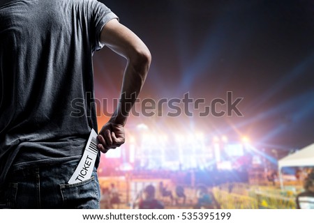 Customer presenting tickets or admission passes watch a rock music concert
