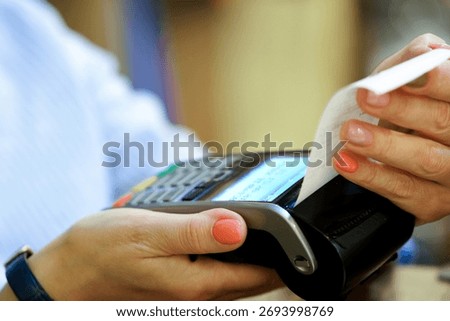 A customer is processing a payment using a card reader and is receiving a printed receipt for their transaction