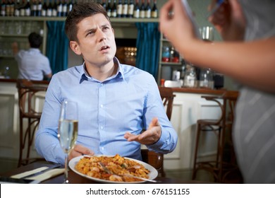 Customer In Restaurant Complaining To Waitress About Food