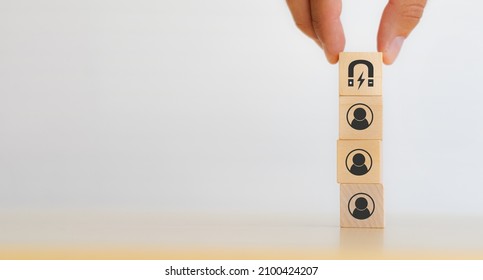 Customer retention concept. Inbound marketing strategy. Attracting potential customers.  Hand puts wooden cubes with magnet attracts customer icons on beautiful white background and copy space.
