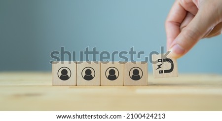 Customer retention concept. Inbound marketing strategy. Attracting potential customers.  Hand puts wooden cubes with magnet attracts customer icons on beautiful grey background and copy space. Loyalty