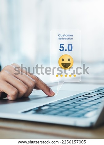 Customer review, satisfaction, feedback, survey concepts. The User give 5 stars rating with smile face icon to service experience, business ranking on online application by laptop computer, vertical.