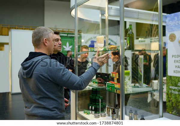 Customer and sales manager standing in front of a\
counter with cannabis products and communicating. November 10,\
2019. Kiev, Ukraine