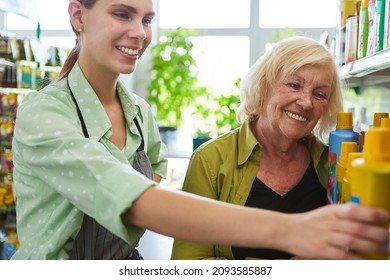 Customer And Saleswoman Together At The Shelf In The Hardware Store Or Garden Center