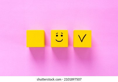 Customer Satisfaction Concept. Yellow Cubes With A Smiling Face And Tick On Pink. Copy Space. Choosing A Better Option And Trusting The Product