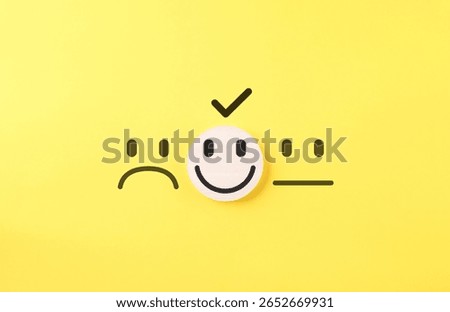 Customer Satisfaction Feedback Choice Concept. Smile face on wooden block selected among sad and neutral faces, symbolizing customer satisfaction, review ratings, and positive feedback in surveys.