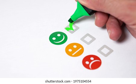 Customer Satisfaction Happy Feedback Rating Checklist And Excellent Business Quality Evaluation Concept With A Customer Hand Checking A Green Smiling Emoticon Face Icon Close Up View.