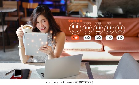 Customer Satisfaction Survey Experience Concept, Happy Asian Woman Drinking Coffee And Pressing Smiling Face Icon With Five Star Excellent Rating For Service Evaluation On Tablet Virtual Touch Screen