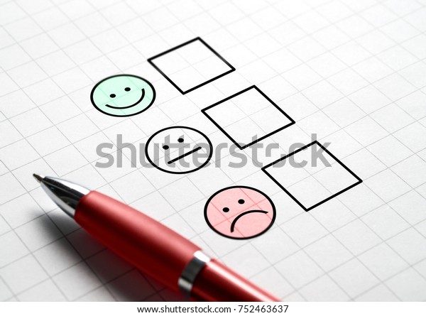 Customer satisfaction survey and questionnaire\
concept. Giving feedback with multiple choice form. Pen, paper and\
emotion smiley face\
icons.