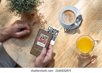 A Customer Scanning A Qr Code With His Cell Phone In A Bar Or Restaurant To Read The Menu. The Hospitality Industry And New Technologies