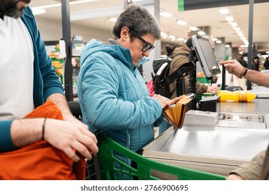 Customer selecting payment method from her wallet at the cash register