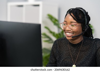 Customer service agent, financial advisor call center employee sits at desk in company in front of computer screen, headphones with microphone on ears, connecting with caller, solving problem