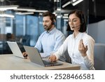 Customer service agents in office using laptops and headsets, demonstrating teamwork and communication. Professionals engaged in support tasks, focused on client satisfaction and technology-driven