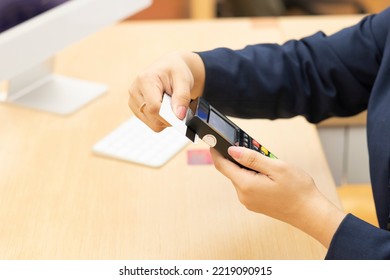 A Customer Service At Bank Swiping A Card On Pin Pad Machine.
Woman Hands On A Table.