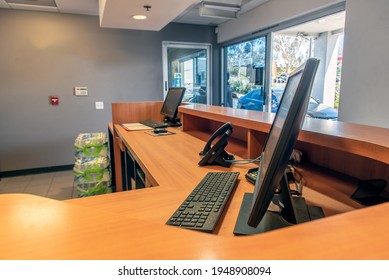 Customer Service Counter With Computer, Keyboard, And Phone Sit Ready For Opening Of The Storefront.