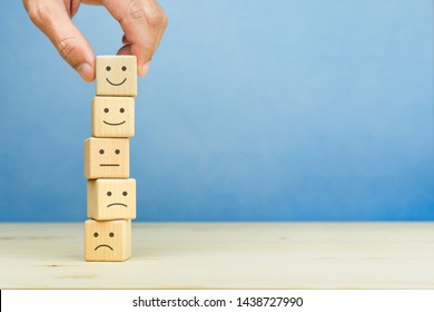 Customer service evaluation and satisfaction survey concepts. The client's hand picked the happy face smile face symbol on wooden blocks, copy space - Shutterstock ID 1438727990
