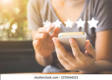 Customer Service Experience And Business Satisfaction Survey. Woman Hand Using Smart Phone With Icon Five Star Symbol To Increase Rating Of Company Concept