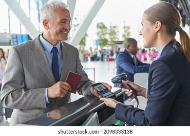 Customer service representative scanning smart phone qr code boarding pass at airport check-in counter