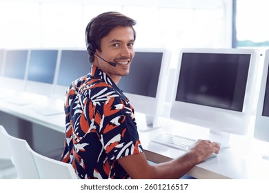 Customer service representative smiling while using headset at computer in office, copy space. Call center, technology, communication, support, professional, employee