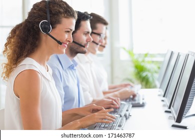 Customer Service Representatives Working At Desk In Office